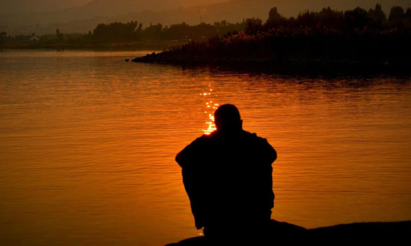 man sitting looking at the sunset