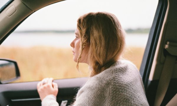 woman thinking from afar inside the car