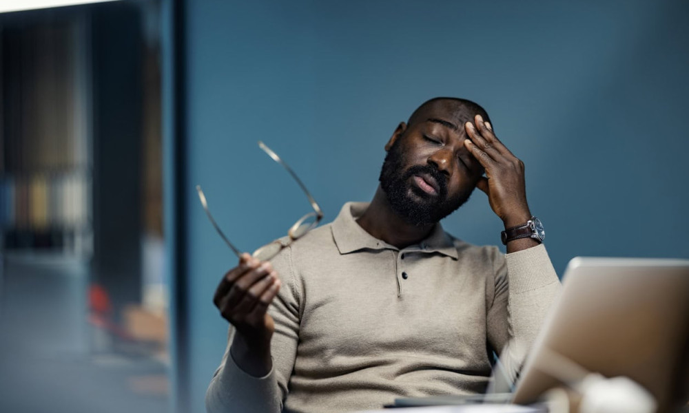 stressed businessman suffering from headache working late