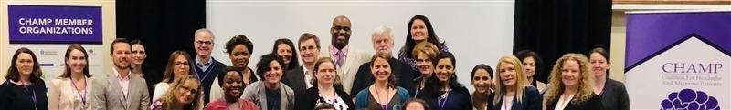 A group of people posing together indoors in front of banners that read "CHAMP Member Organizations" and "CHAMP.