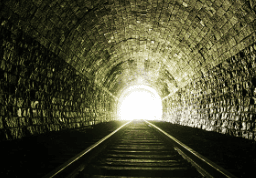 Light at the end of railroad tunnel. Natural lighting